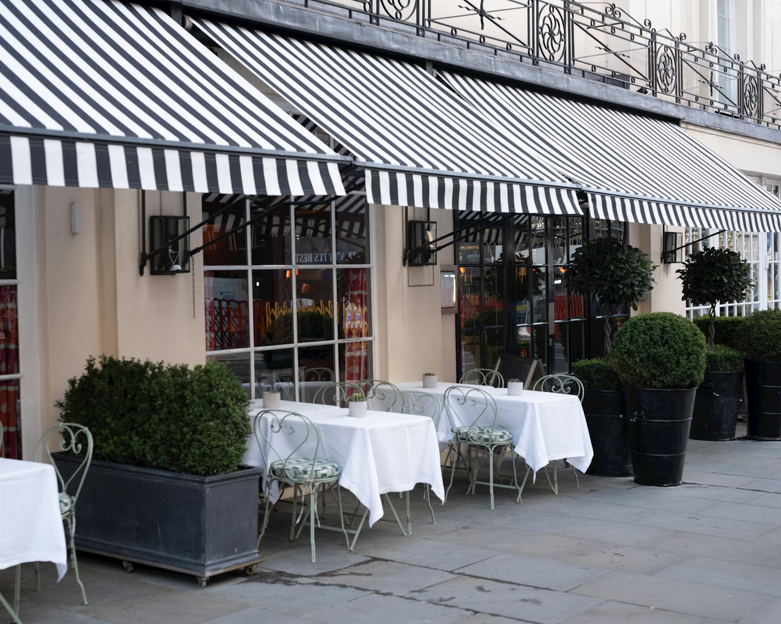 Cafe storefront with a classic striped awning and outdoor seating