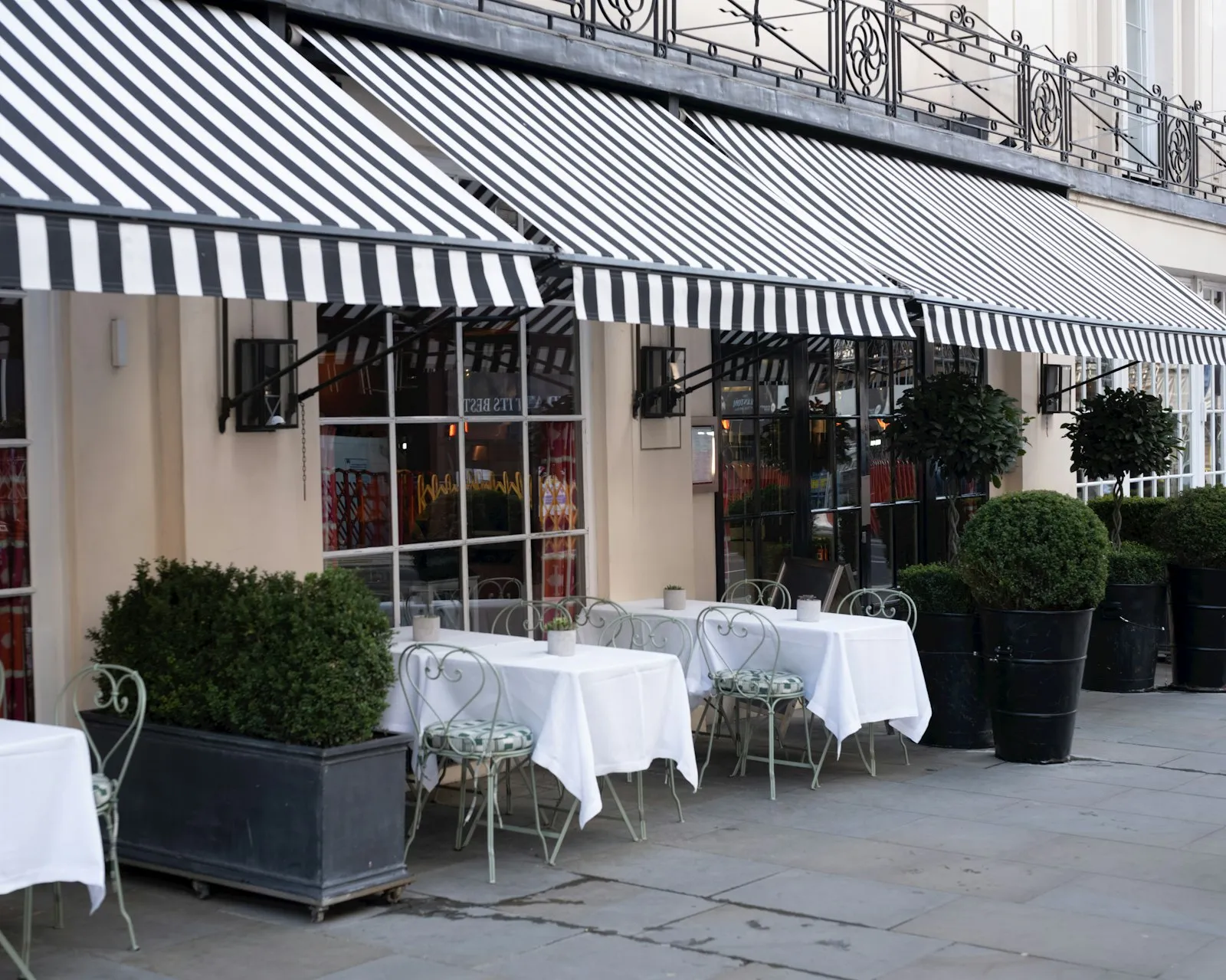 Cafe storefront with a classic striped awning and outdoor seating