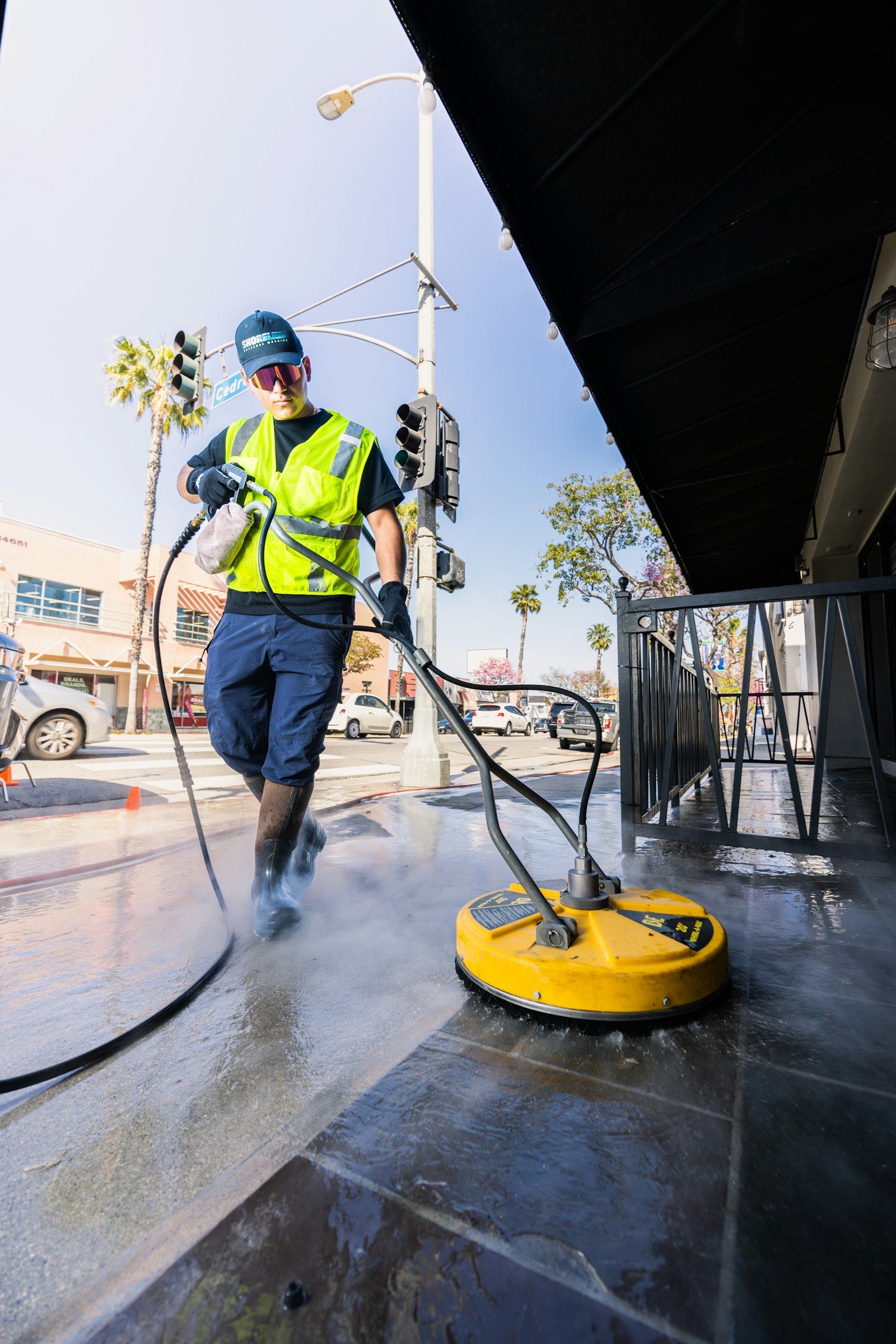 Pressure washer cleaning a concrete driveway surface