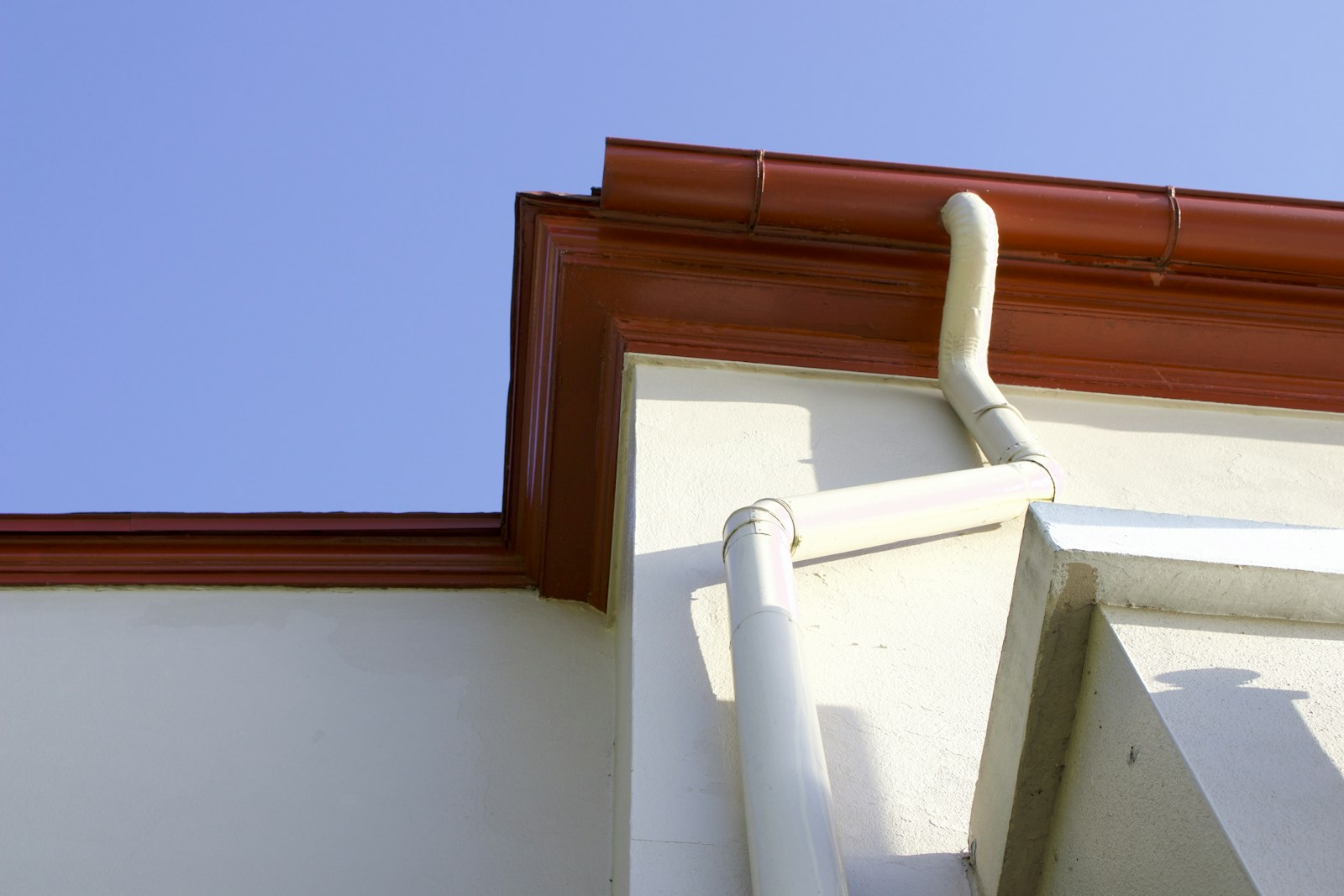 Close-up of a rain gutter and downspout on a house
