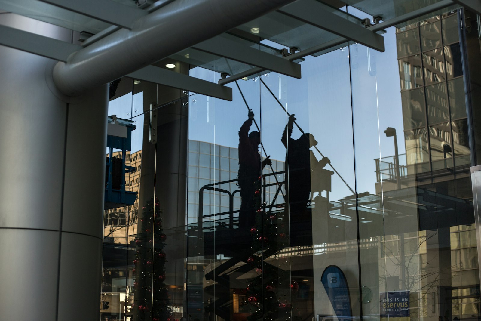Window cleaner squeegeeing a large glass facade